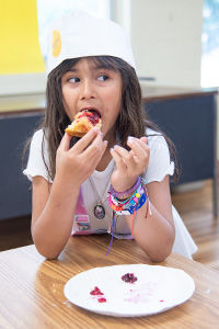 girl tasting baked goods