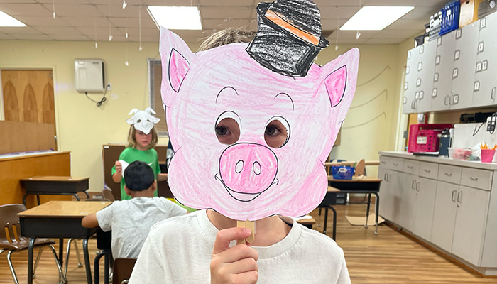 kid holding up pig mask